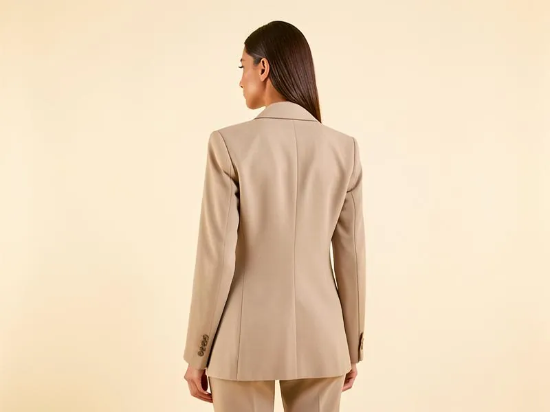 Mujer de espaldas con blazer beige y postura erguida
